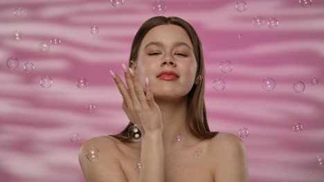 portrait of woman with bubbles and pink background a woman surrounded by bubbles with a softly lit pink background the image evokes a sense of calm and beauty slow motion