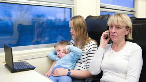 Pasajeros-En-El-Tren-Viendo-Videos-En-Una-Computadora-Portátil-Y-Hablando-Por-Teléfono