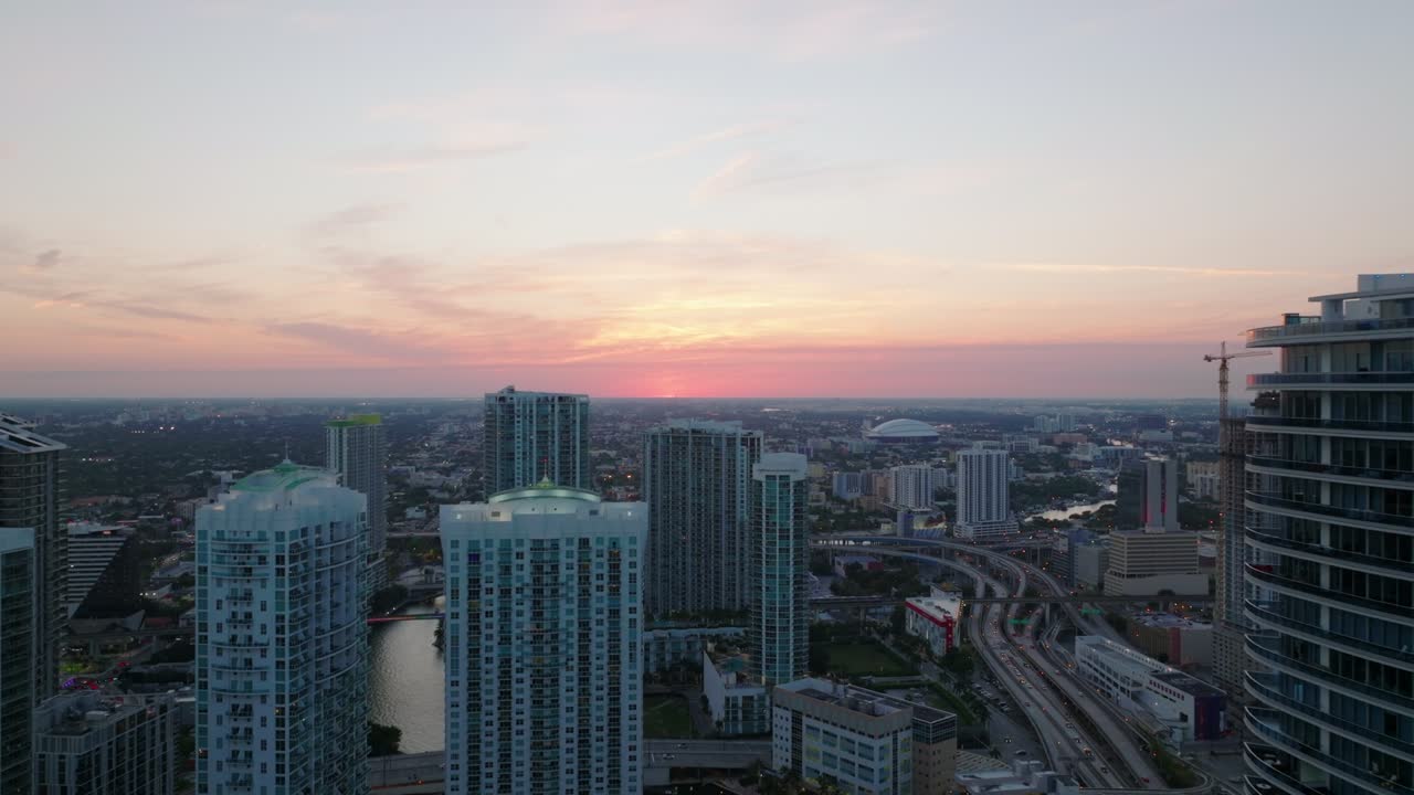 Voo para trás sobre a cidade. Edifícios de apartamentos altos em um bairro urbano moderno ao anoitecer. Miami, EUA.