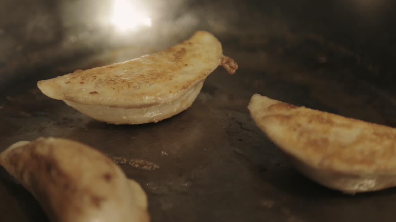 girar los lados de las albóndigas fritas crujientes con una pinza de acero - primer plano