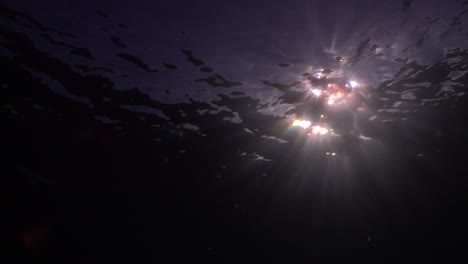 Sun-rays-shining-through-the-ocean-surface-at-dusk-close-up