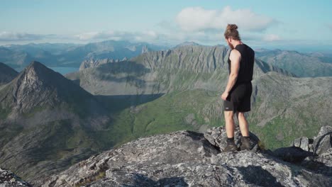 lonketinden, noruega - aventurero de pie en la cumbre - toma estática