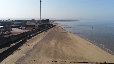 Popular-seaside-Rhyl-resort-town-aerial-descending-in-push-view-above-coastal-beach-shore