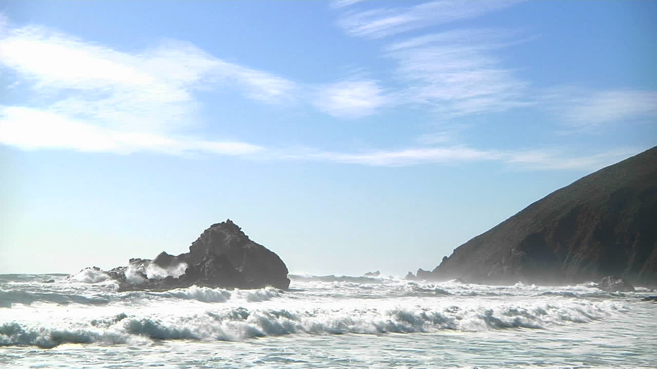 캘리포니아 해안선을 따라 화창한 날에 파도가 해안으로 밀려옵니다.