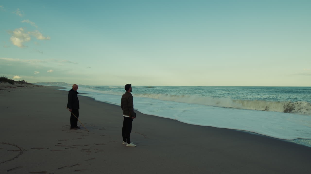 Father, Lord, and Son Watch the Ocean with Waves Crashing on the Beach