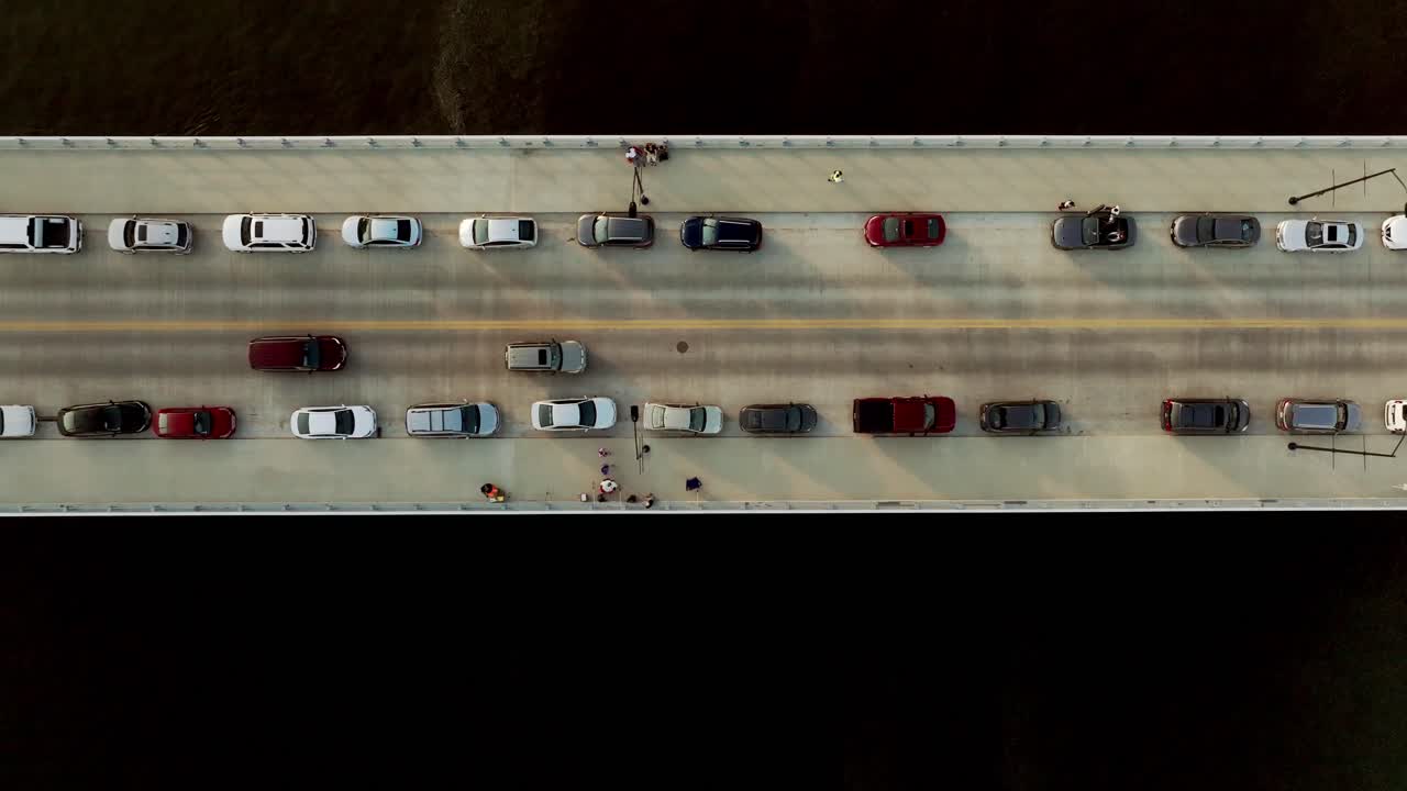 아이오와 주 데스 모인즈의 다리에 있는 차량들이 데스 모인즈 강을 가로질러 드론 비디오를 통해 아래로 내려다보고 있습니다.