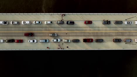 Cars-on-bridge-in-Des-Moines,-Iowa-over-Des-Moines-River-with-drone-video-overhead-looking-down-stable