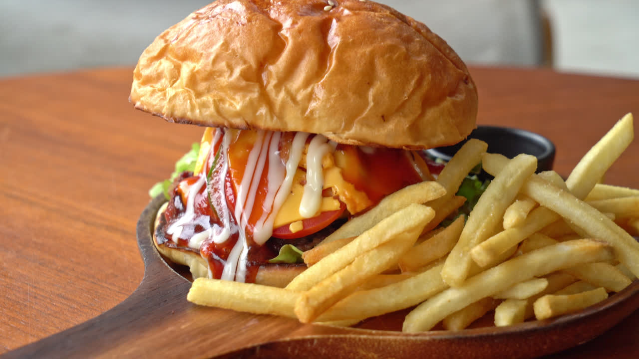 치즈와 나무 접시에 소스와 함께 쇠고기 햄버거