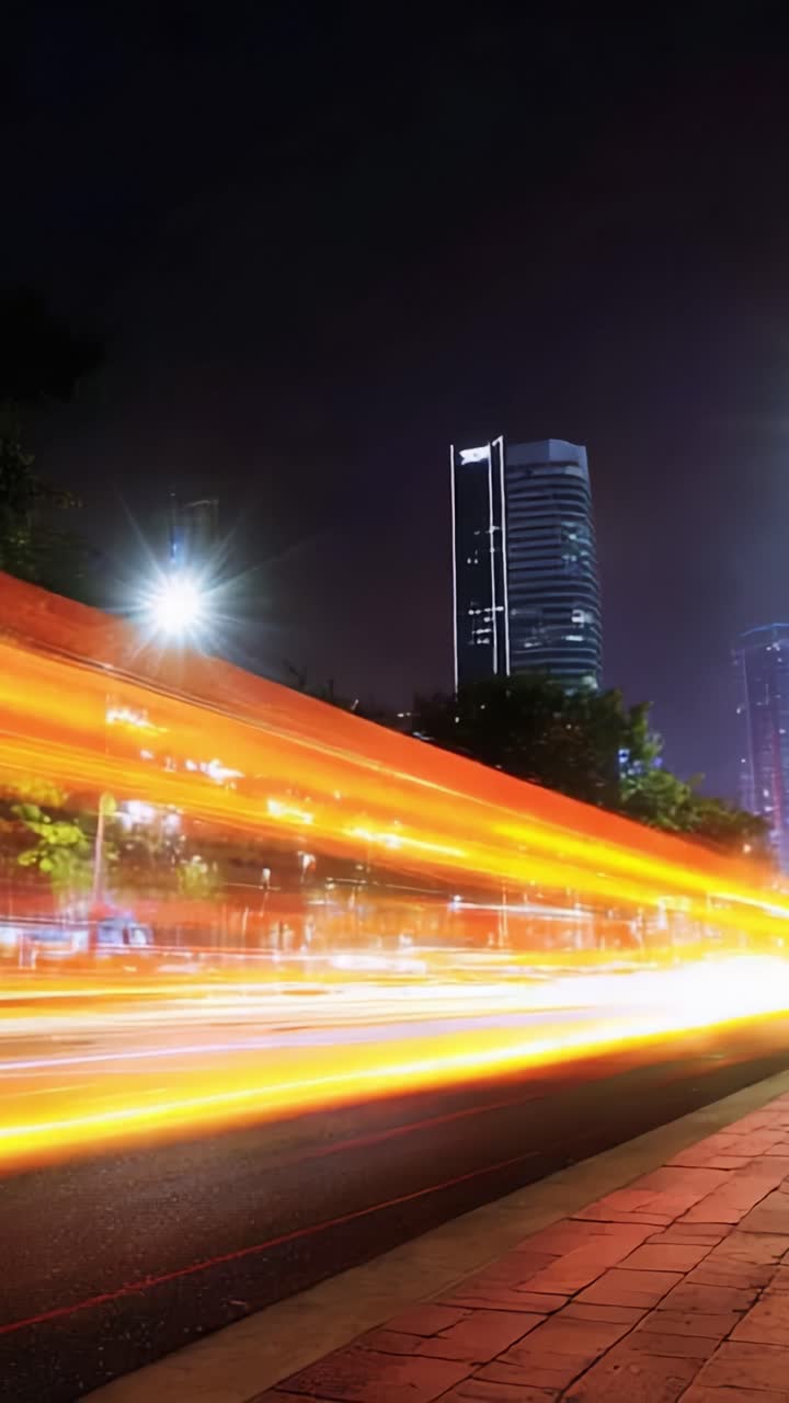 Nighttime Cityscape with Blurred Traffic Lights and Tall Buildings ...