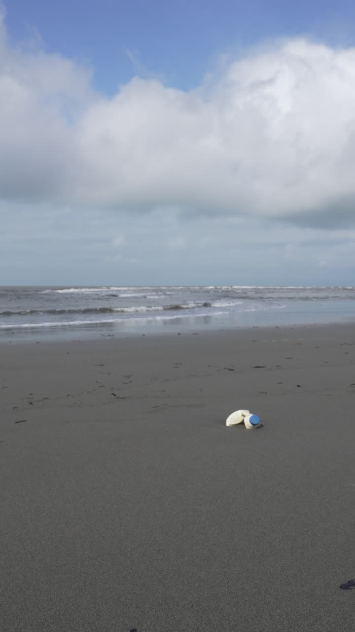 Plastic waste on the beach pollution environmental Impact, vertical video