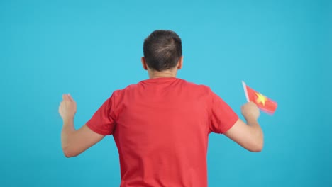 Rear view of a man waving a vietnamese pennant