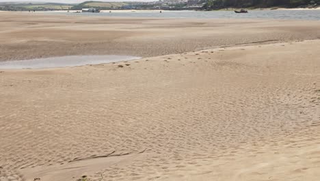 vertical pan from beach to sky of view from daymer bay towards padstow at low tide