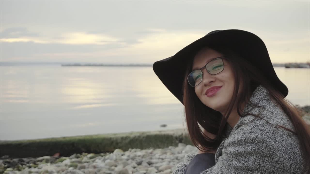 Woman sitting on the beach at sunset