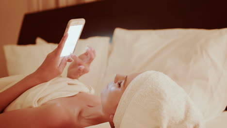 woman using phone in bed at night