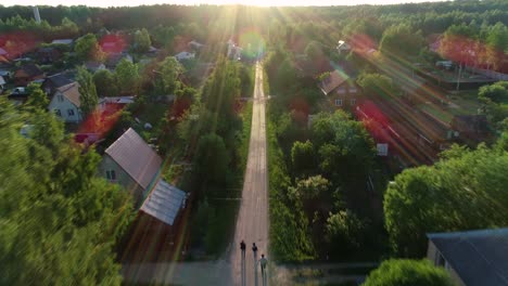 the village road. the car rides along the road between trees and houses.