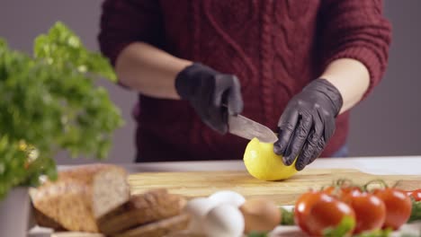 slow-motion of a chef slicing a ripe yellow melon on a wooden board. black gloves ensure hygiene, while fresh ingredients like tomatoes, eggs, herbs, and bread create a vibrant kitchen setting