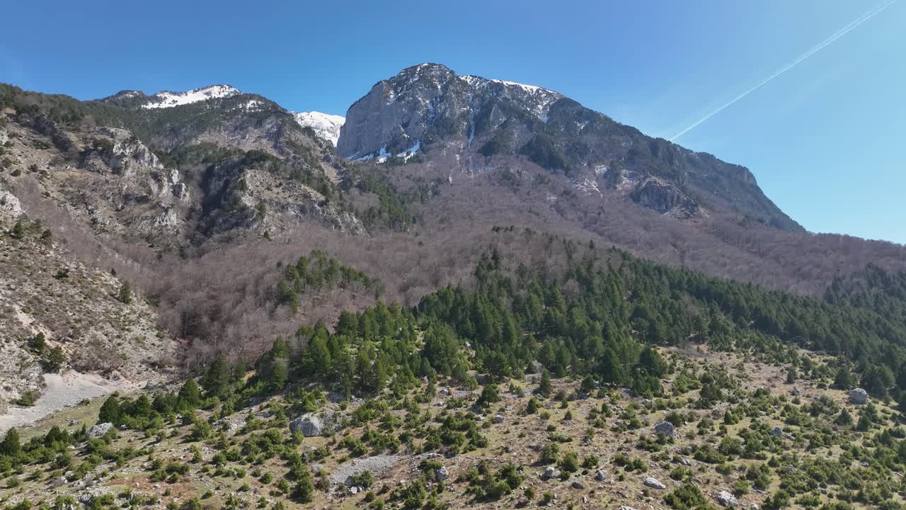 toma aérea de la cima de una montaña rocosa con hermosos paisajes y bosques en la base