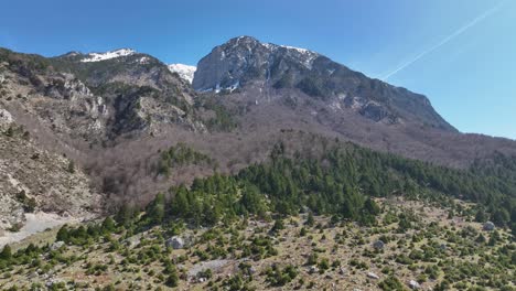 Aerial-shot-of-rocky-mountain-top-with-beautiful-scenery-and-forest-on-the-base