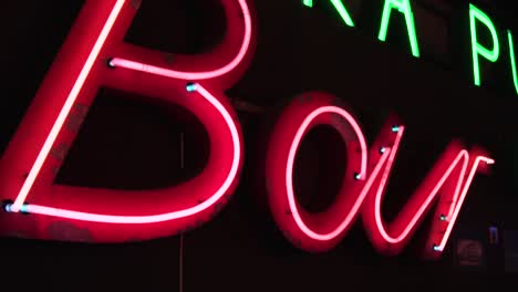 pink neon sign in slow motion in a dark room