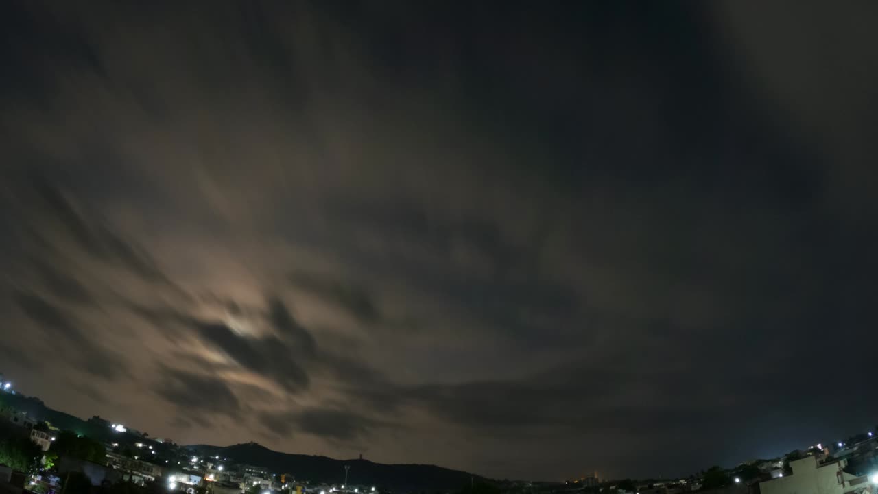 4k 밤에서 아침 시간은 하늘에 달과 함께 도시 위에 있습니다.