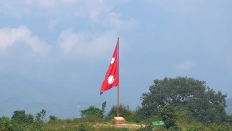 Ein-Blick-Auf-Eine-Große-Nepalesische-Flagge-Auf-Der-Spitze-Eines-Hügels,-Die-Im-Wind-Weht