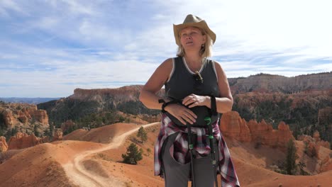 a woman takes a breath and fixes her hair on a short respite in the bryce canyon