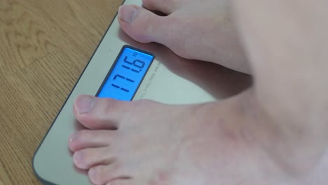 closeup shot of man stepping on a weight scale