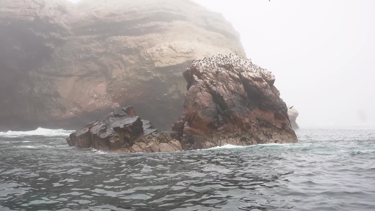 pequeña isla rocosa en tiempo de niebla en el océano pacífico en la reserva nacional de paracas, ica perú durante el invierno