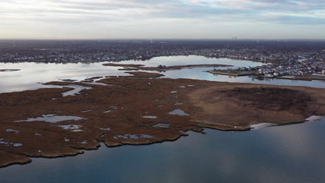 An-aerial-shot-over-Baldwin-Bay-near-Freeport,-NY-during-sunset