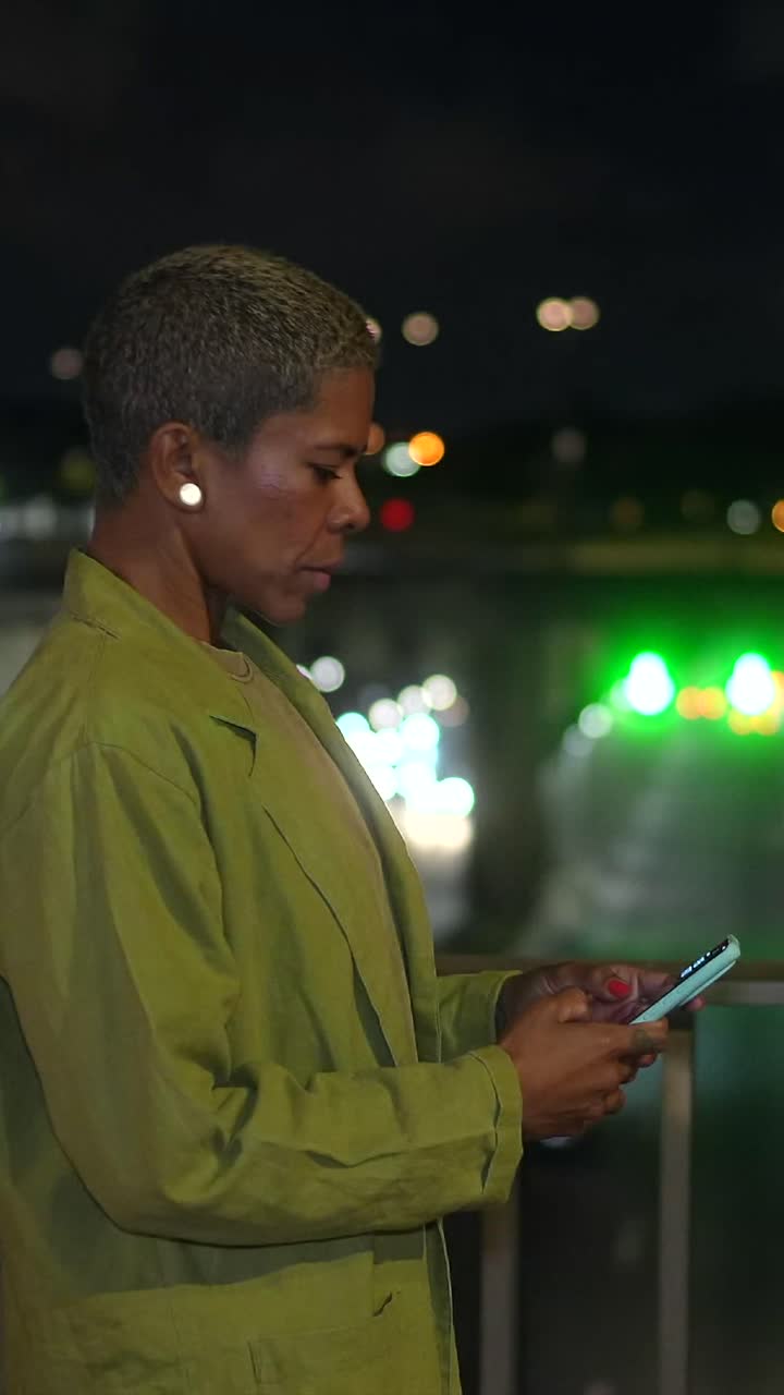 Woman in jacket looking at city lights at night