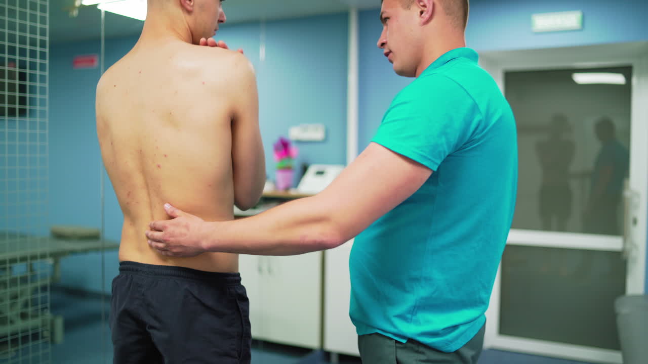 Patient assisted by physical therapist. Physiotherapist working with young patient in clinic