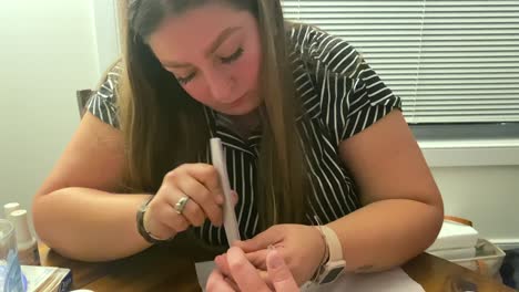 mujer joven archivando y dando forma a las uñas de un cliente con una tabla de esmerilla, pedicura