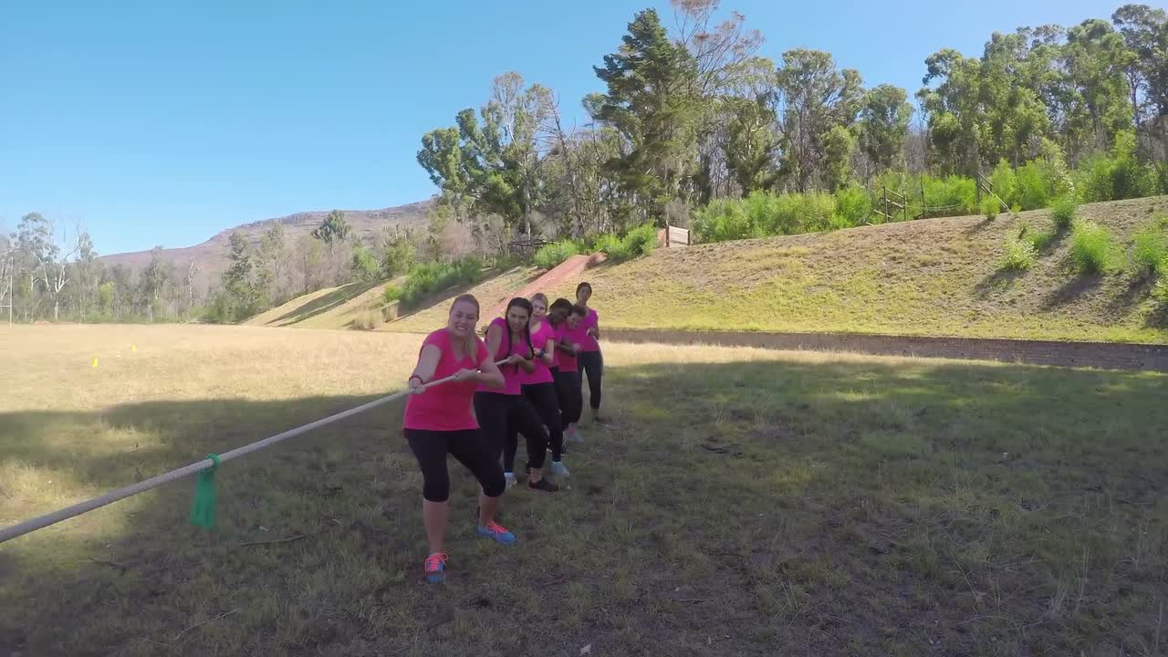 유니폼을 입은 아이들이 장애물 코스 4k에서 견인기를 치고 있습니다.