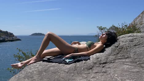 Girl-in-bikini-sunbathing-on-stone