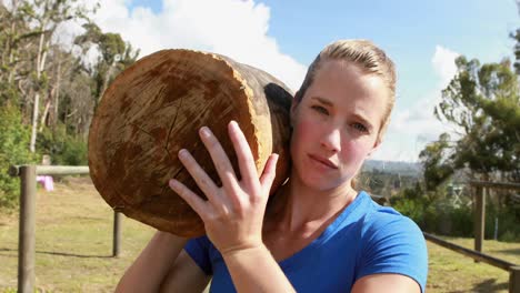 mujer en forma llevando un pesado tronco de madera