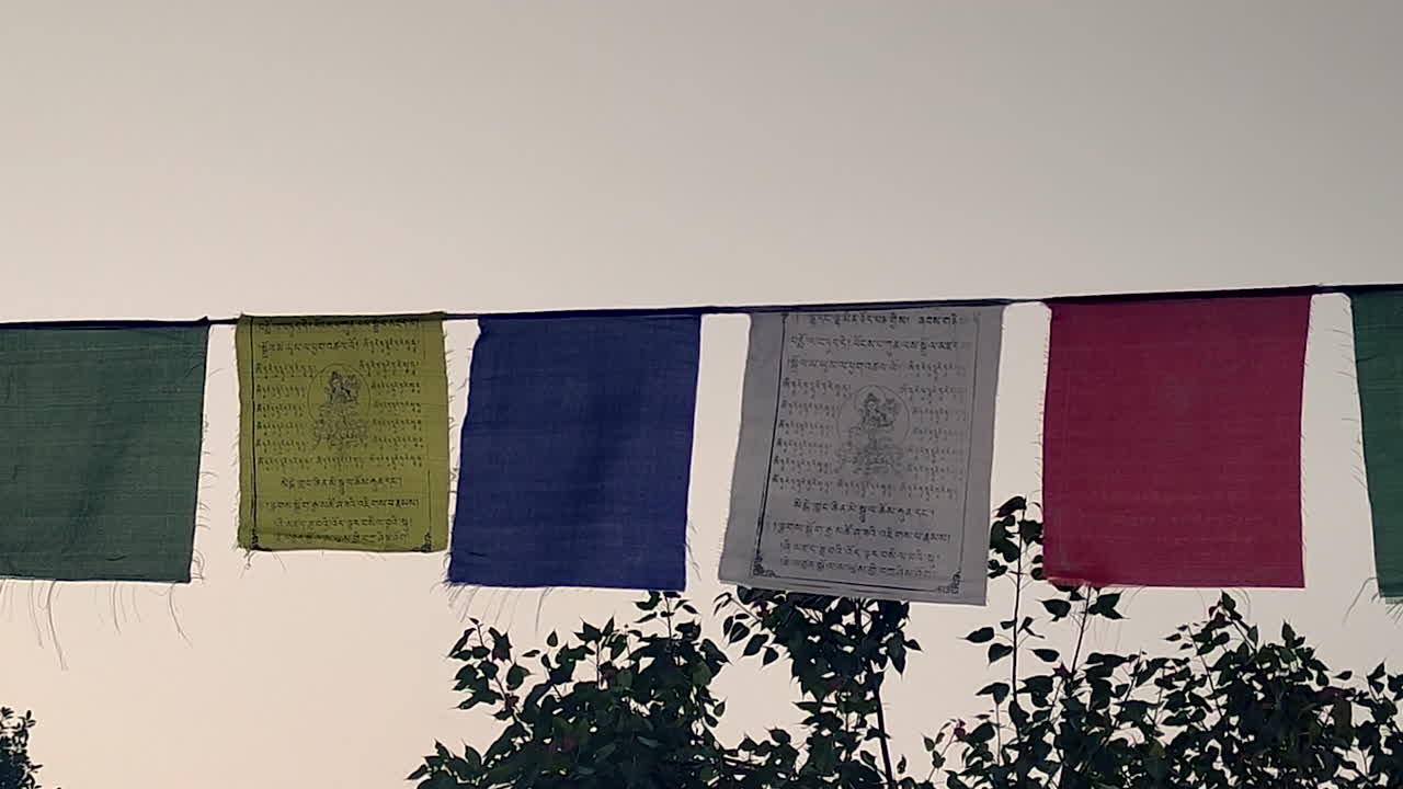Buddhist prayer flags hanging outdoors showing spirituality, peace, meditation culture, religious tradition, colorful fabric flags moving in natural light