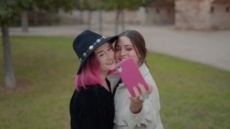dos mujeres tomando una selfie en un parque