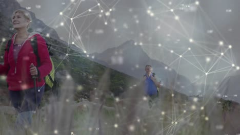 feliz pareja de ancianos caucásicos haciendo senderismo en el campo, a través de una red móvil de conexiones