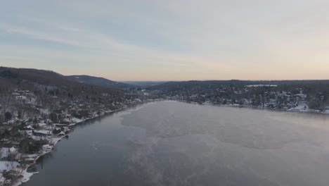 partially frozen lake on winter sunrise in quebec province, canada