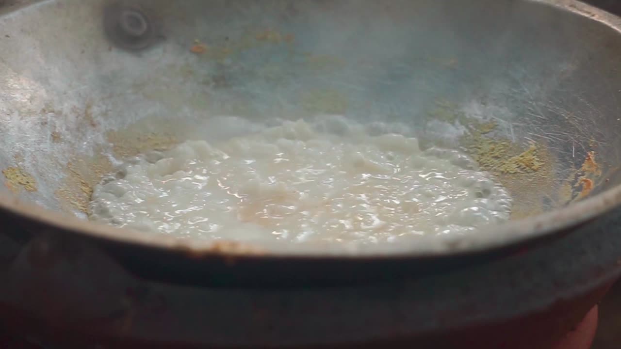 Close up of bubbling egg on wok pan to make Indonesian street food, Kerak Telor