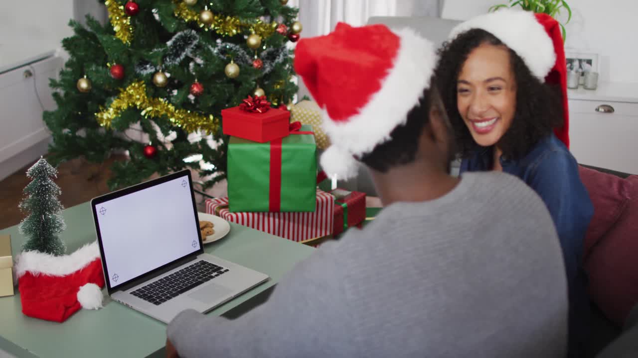 feliz pareja afroamericana usando una computadora portátil con espacio de copia en la pantalla