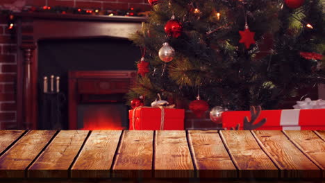 wooden foreground with christmas background of tree and gifts by fire