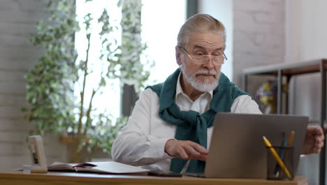 older man working on laptop