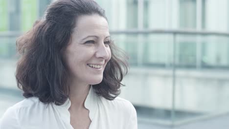 Cheerful-Female-Office-Employee-Chatting-With-Colleague-During-Break,-Sitting-Outside,-Speaking-And-Smiling