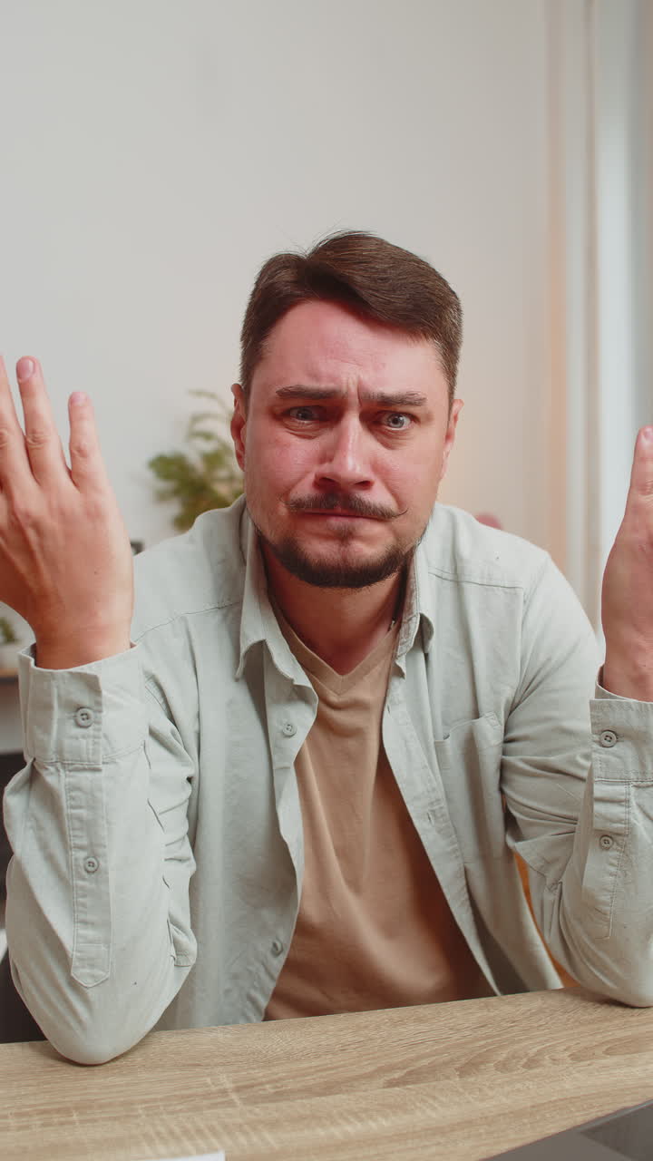 Shocked young man becoming surprised by lottery results bad fortune loss unlucky news at home