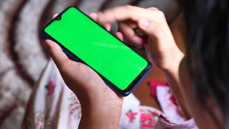 persona que utiliza un teléfono inteligente con pantalla verde