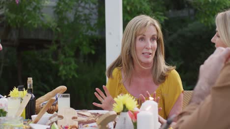 Senior-woman-talking-while-having-lunch-outdoors