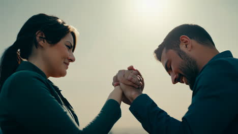 friendly arm wrestling match between two adults during sunset