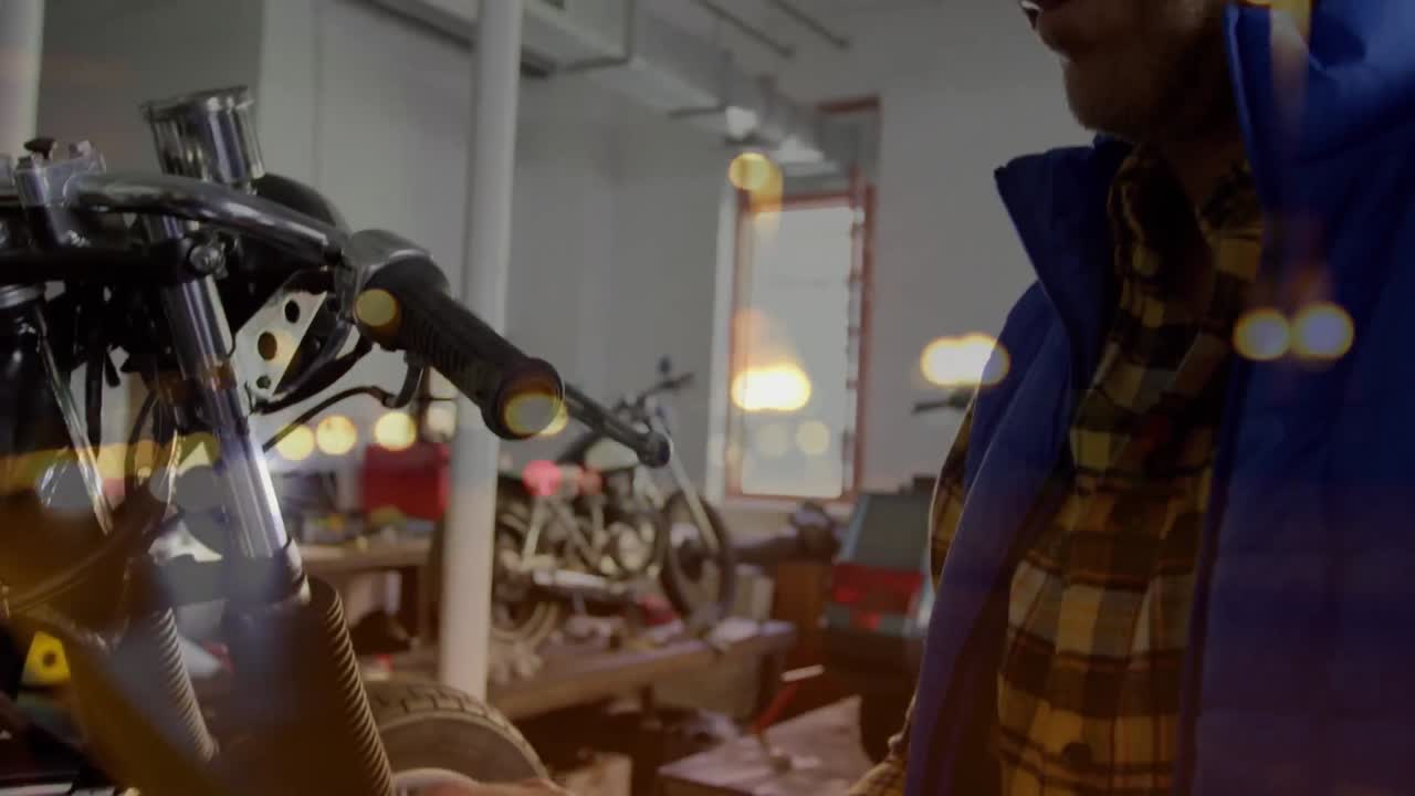 animación de luces parpadeantes sobre un mecánico caucásico que sostiene un teléfono inteligente en una motocicleta