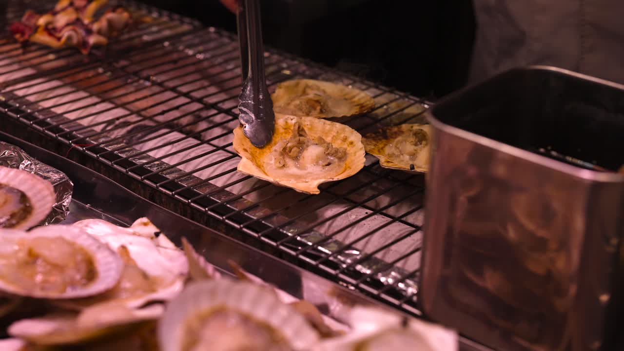 Scallops being grilled over charcoal flames